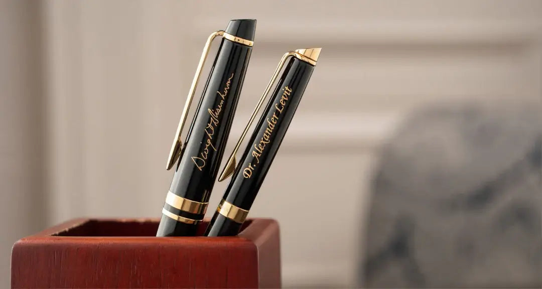 Two engraved pens sitting in pen holder