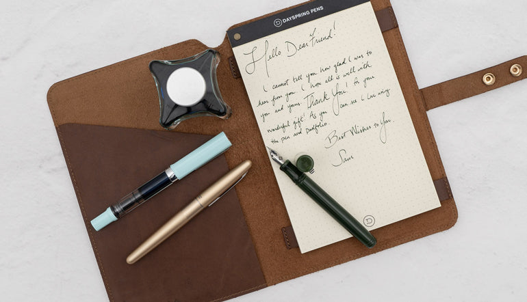 fountain pen on top of a notepad