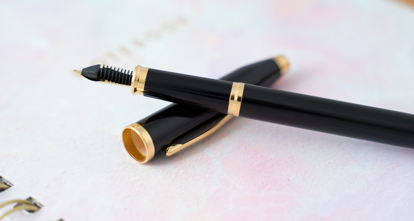 Uncapped Black Century II Fountain pen sitting on notebook.