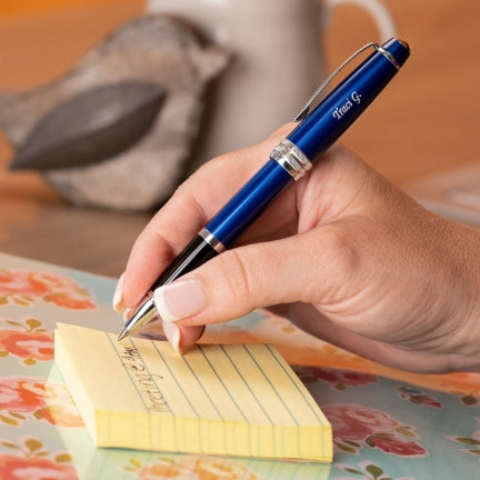 Woman writing with a Bailey Blue Rollerball on a sticky note