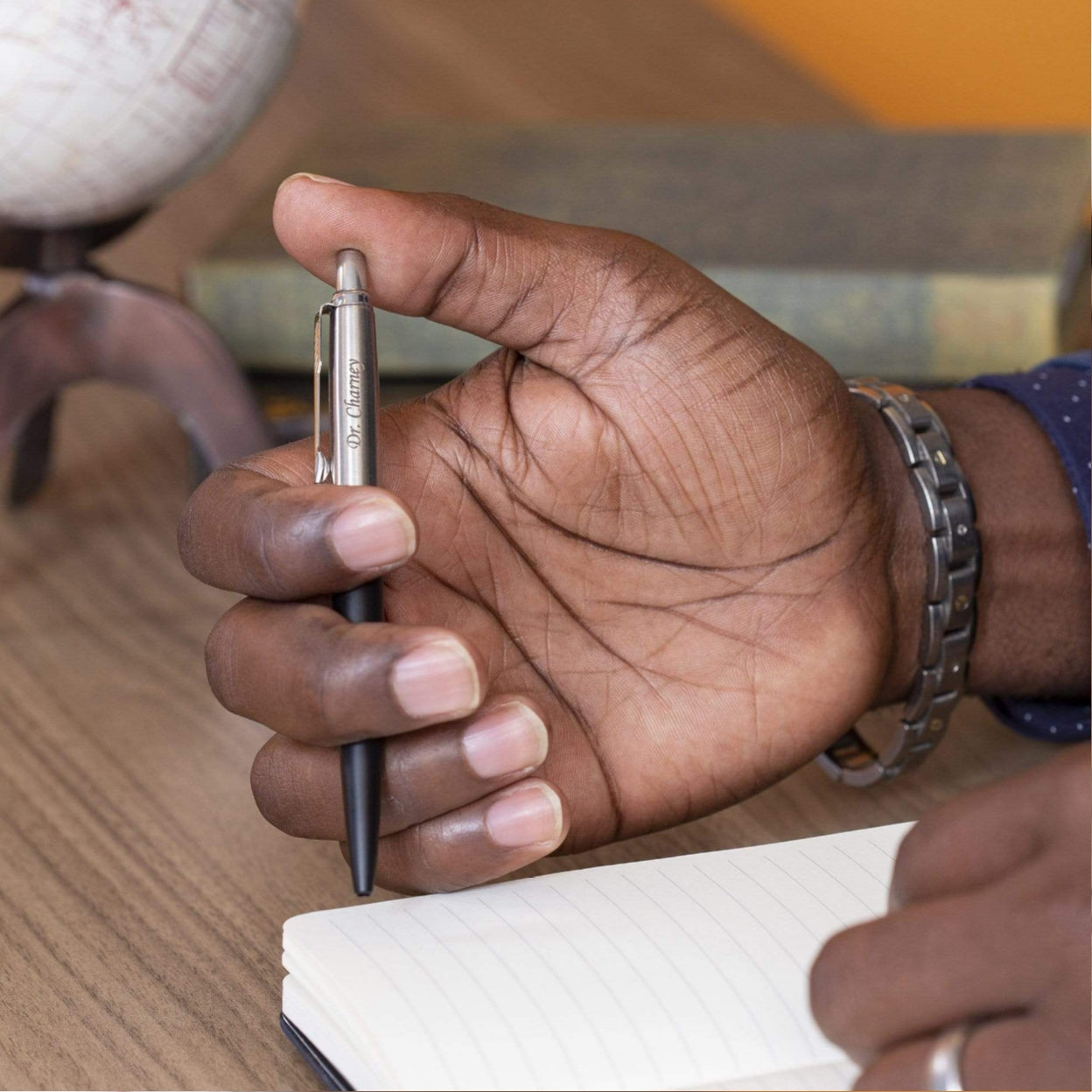 Man holding engraved Jotter Black Ballpoint to take notes