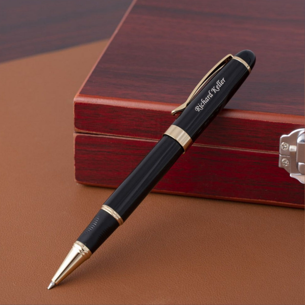 Engraved Alexandria Black Rollerball Placed next to a wood box