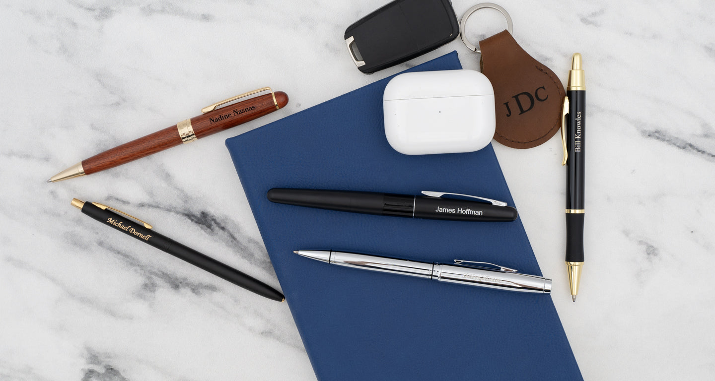 Affordable engraved professional pens on a table with notebook and keys