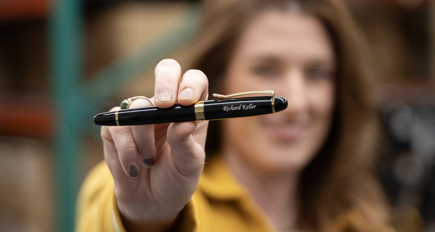 The Alexandria Black Rollerball Pen held by Jamie