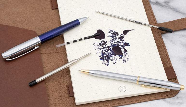 Ballpoint Ink spilled out with pens and refills around it