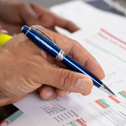 Man writing with a Bailey Blue Ballpoint on a spreadsheet