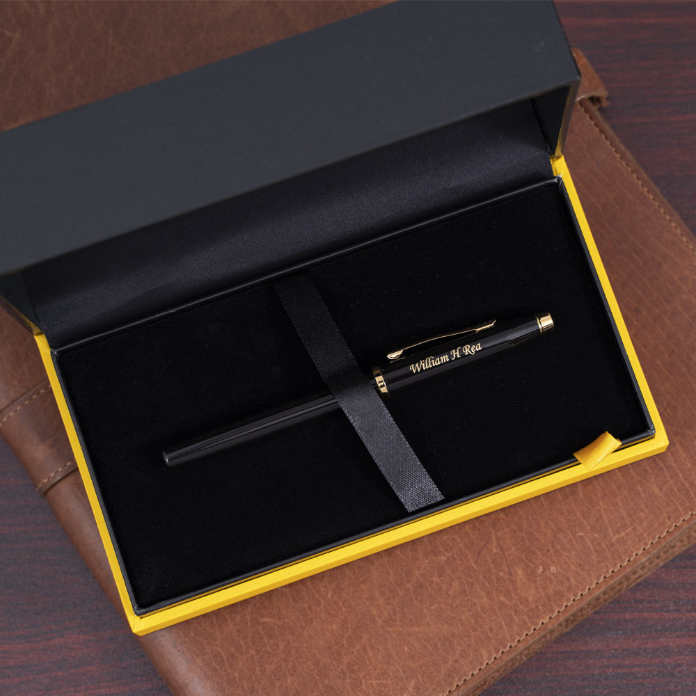 Engraved Century II Black Rollerball in case on top of journal