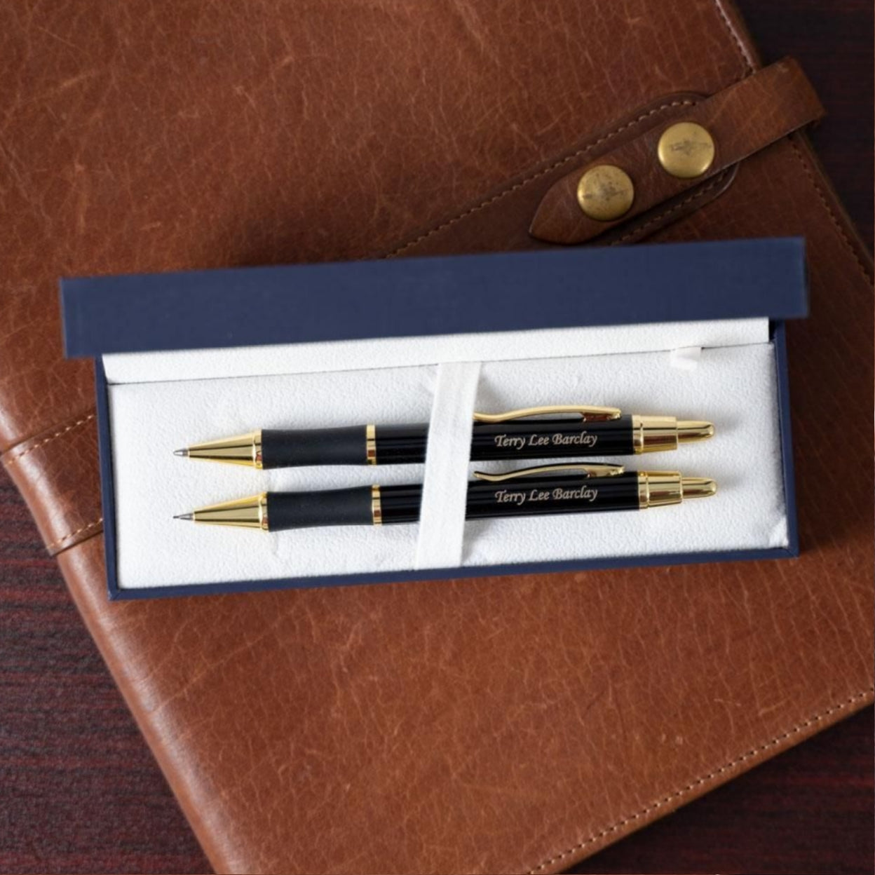 Engraved Monroe Black Pen and Pencil Set on display in box sitting on journal