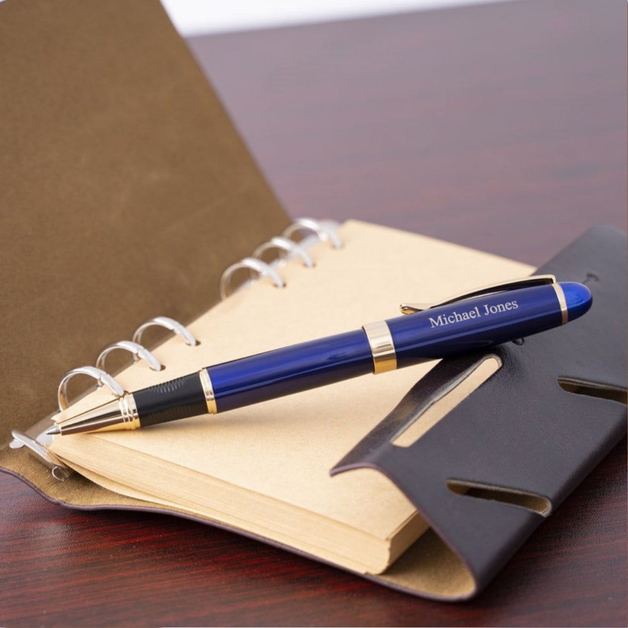 Engraved Alexandria Blue Rollerball placed on open notebook