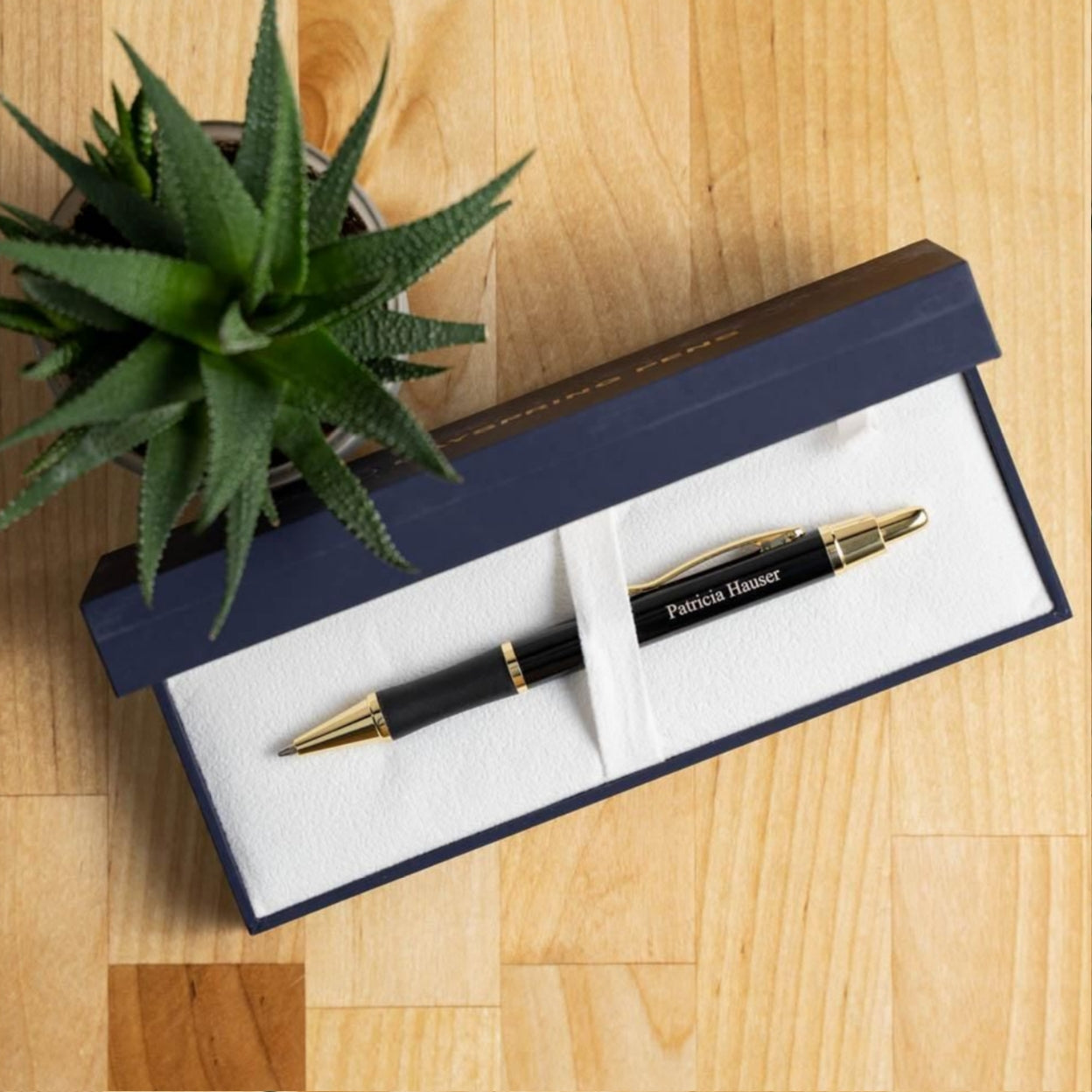 Engraved Monroe Black Ballpoint on display in box next to plant