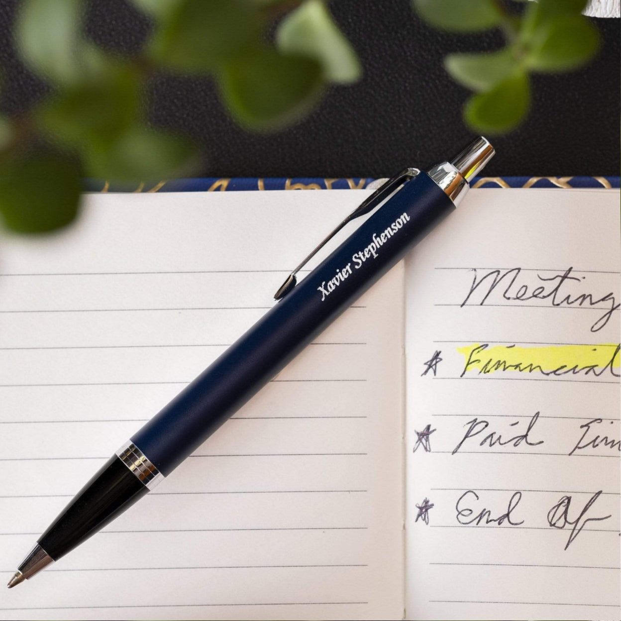 Engraved IM Blue Ballpoint set on top of notebook