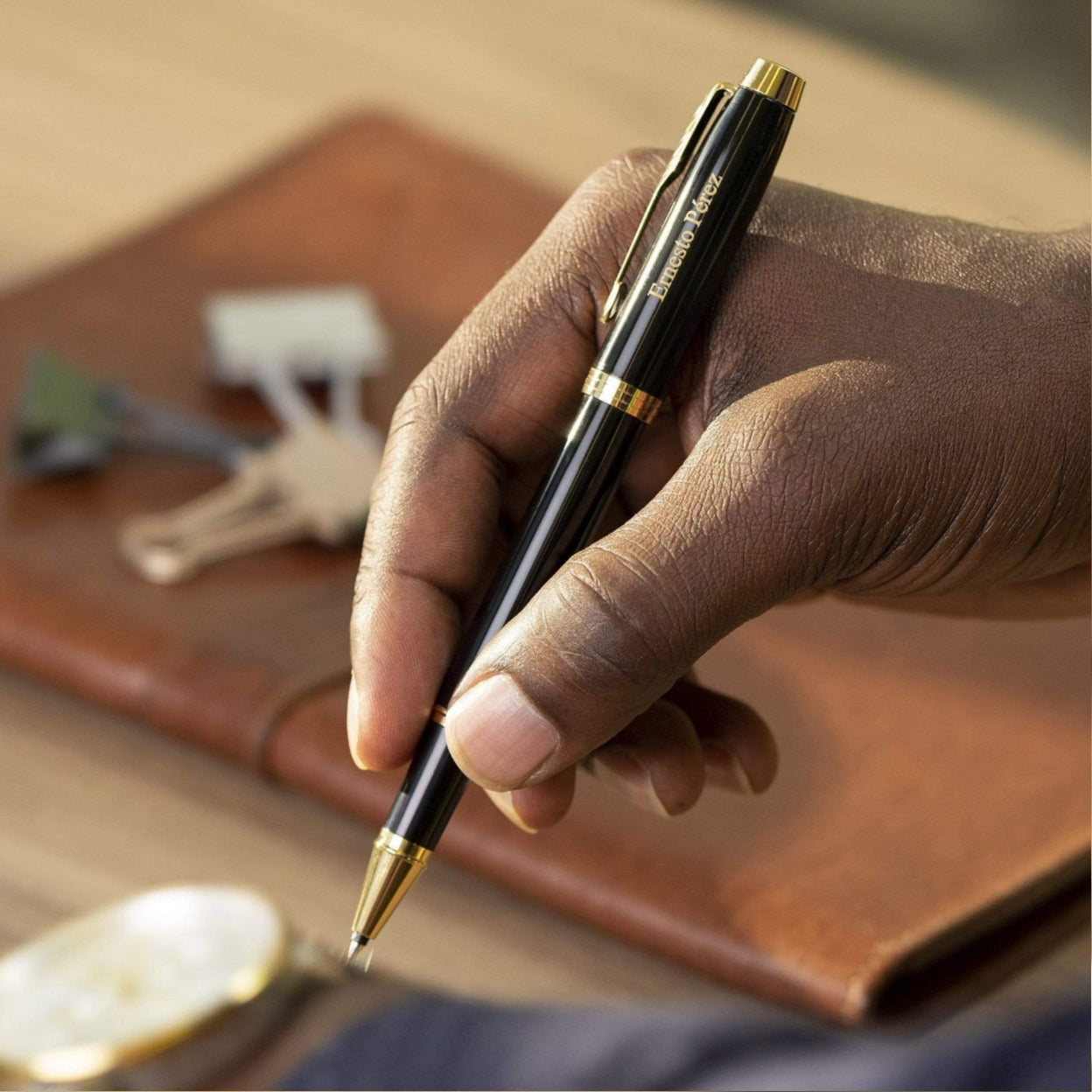 Man holding IM Black and Gold Rollerball to take notes
