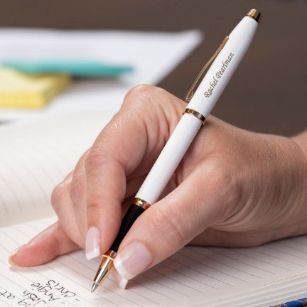 Woman holding engraved Century II White Rollerball while taking notes
