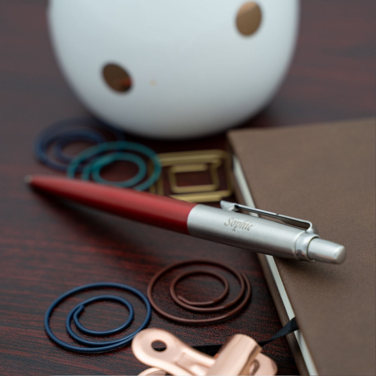 Engraved Jotter Red Kensington Placed on desk next to journal