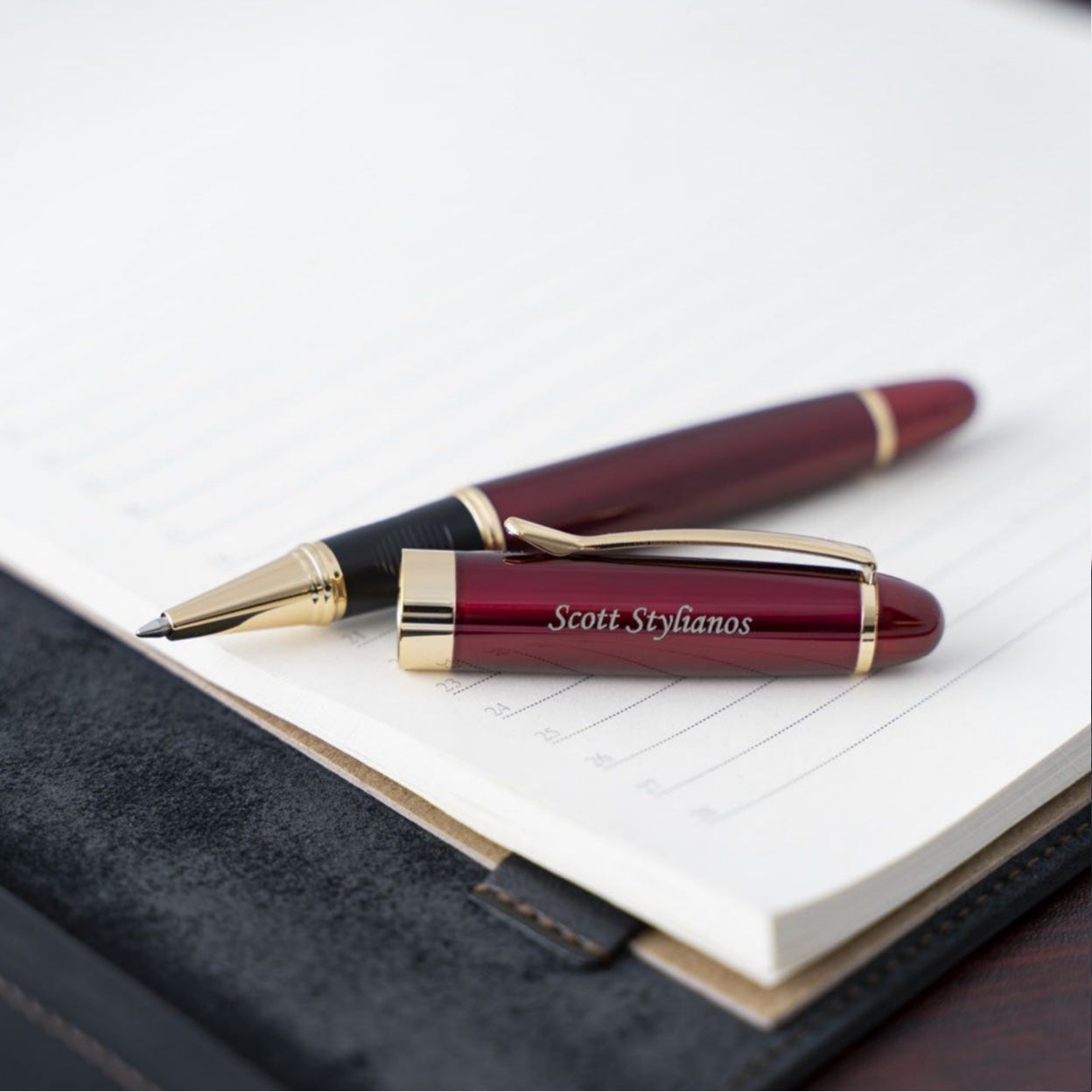Engraved uncapped Alexandria Red Rollerball placed on a dayplanner