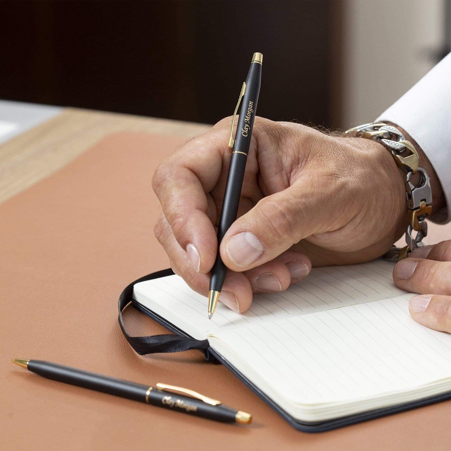 Man holding engraved Classic Century Black Pen and Pencil Set to take notes