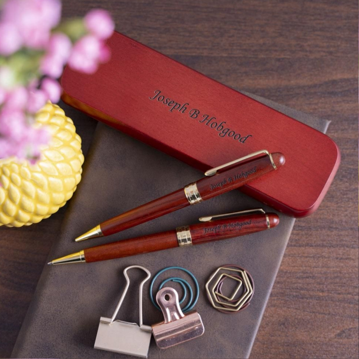 Engraved Rosewood Pen and Pencil Set sitting on engraved case on top of journal