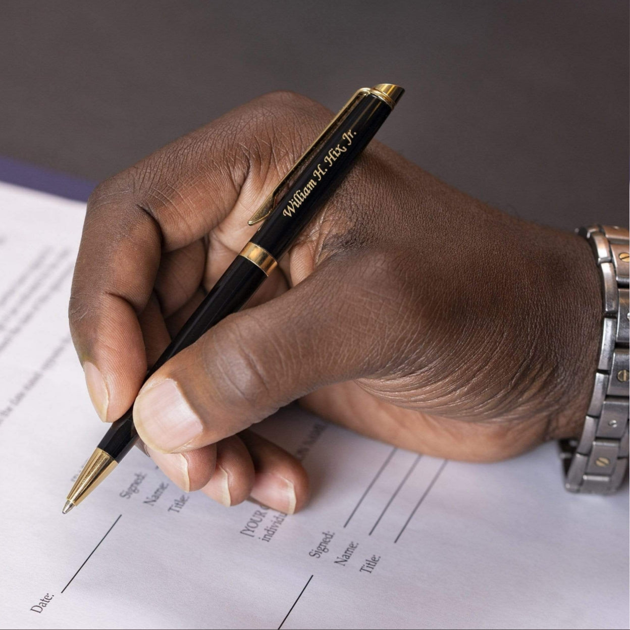 Man holding engraved Hemisphere Black Gold Trim Ballpoint to take notes