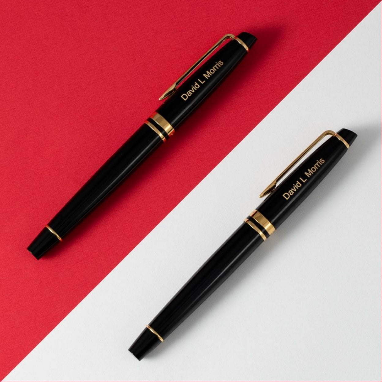 Engraved Expert Black Gold Trim Rollerball Pen on red and white colored table